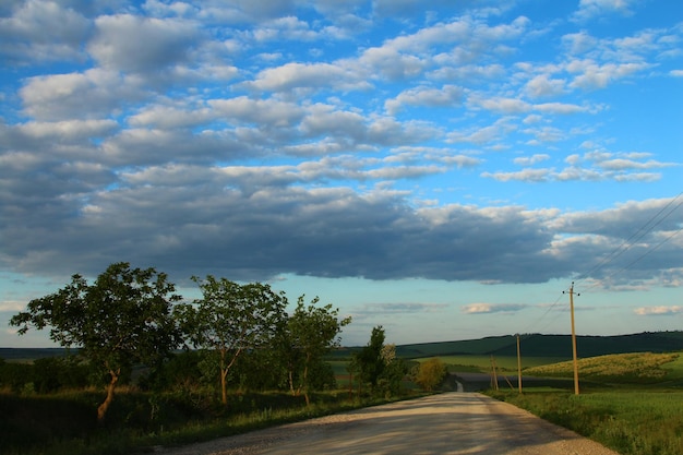 Foto un camino con un cielo que tiene nubes en él