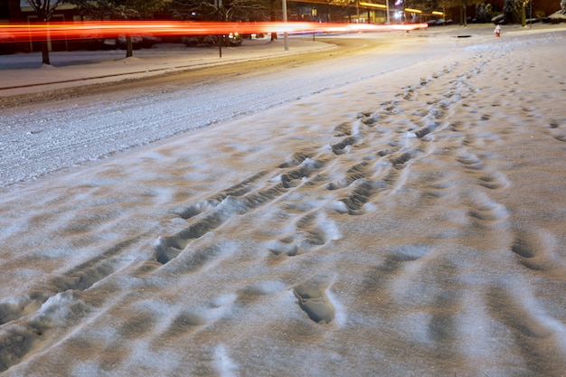 Camino de la ciudad que tiene lugar en la avenida, cubierto de nieve.