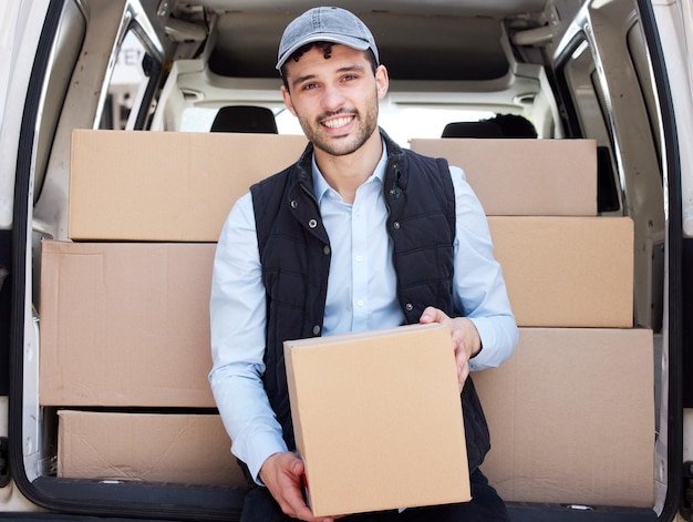 De camino a dejar la siguiente caja Retrato de un joven repartidor cargando cajas desde una furgoneta