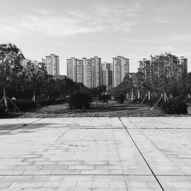 Foto camino entre edificios en la ciudad contra el cielo