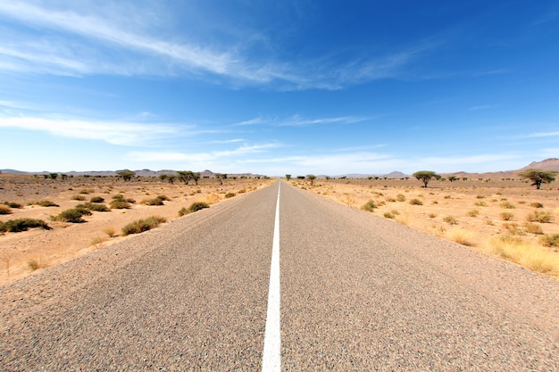 Camino interminable en el desierto del Sahara con cielo azul, África