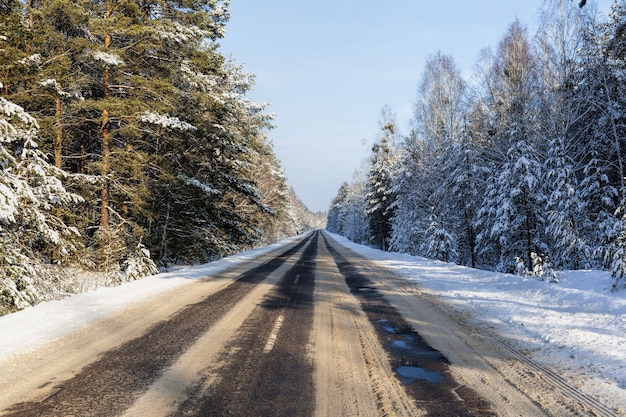 Camino de invierno cubierto de nieve para el tráfico de automóviles