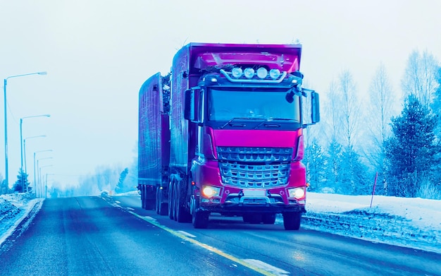 Camino de invierno con nieve. Camión en Finlandia. Camión y paisaje frío de Laponia. Bosque de Europa. Paseo por la autopista de la ciudad finlandesa. Carretera y ruta callejera nevada. Entrega en conducción cuesta abajo