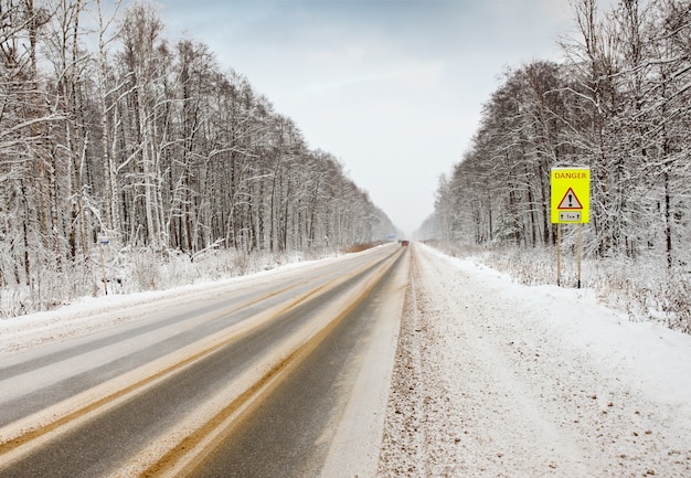 Camino de invierno con señal de advertencia