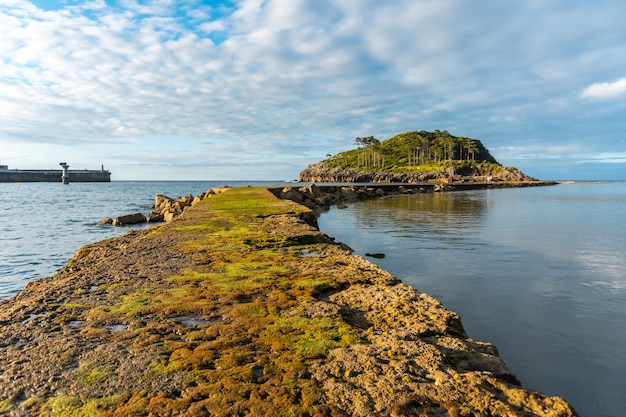 De camino a la isla de San Nicolás durante la marea baja desde la playa de Isuntza en Lekeitio, País Vasco