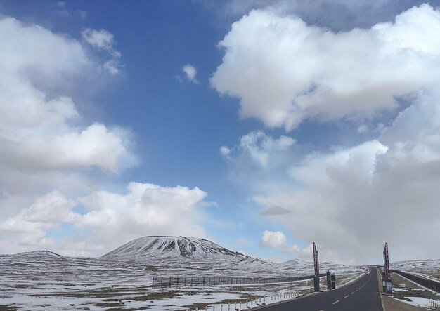 Foto un camino con una montaña nevada al fondo
