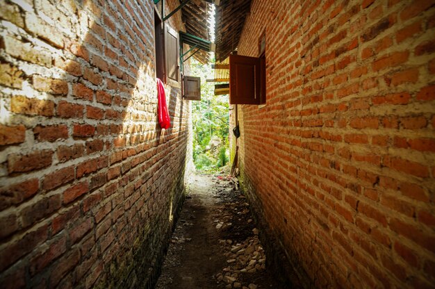 Un camino Narrwo en un pequeño pueblo entre dos paredes de ladrillo de las casas.