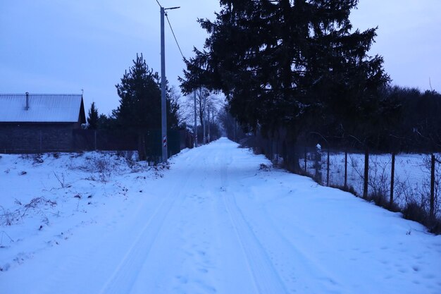 Foto un camino con nieve en él y una valla en el lado derecho