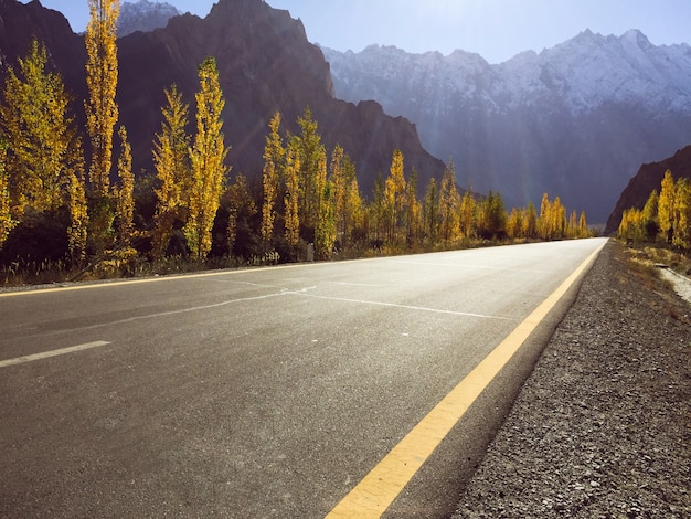 Un camino pavimentado vacío en la carretera de Karakoram contra nieve capsuló la estación del otoño del rangein de la montaña.