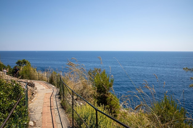 Camino peatonal de Portofino para hacer senderismo por la costa del mar Mediterráneo con barrera protectora.