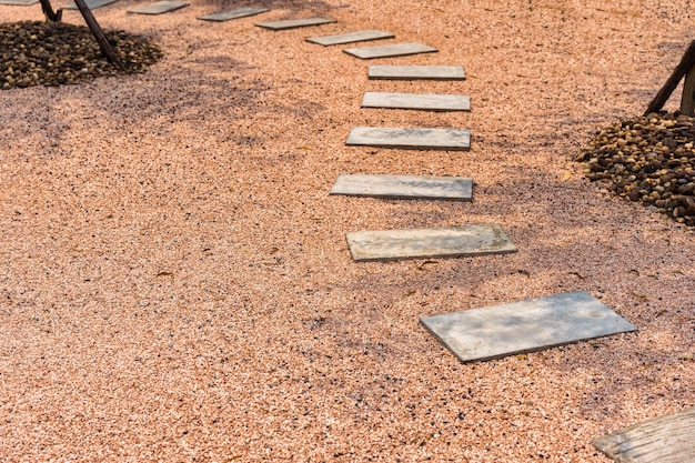 Camino de piedra zen sobre suelo de grava en el jardín