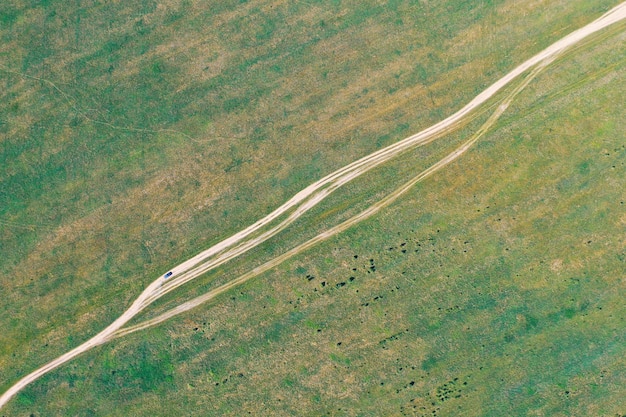 Camino polvoriento de tierra y coche que pasa por él