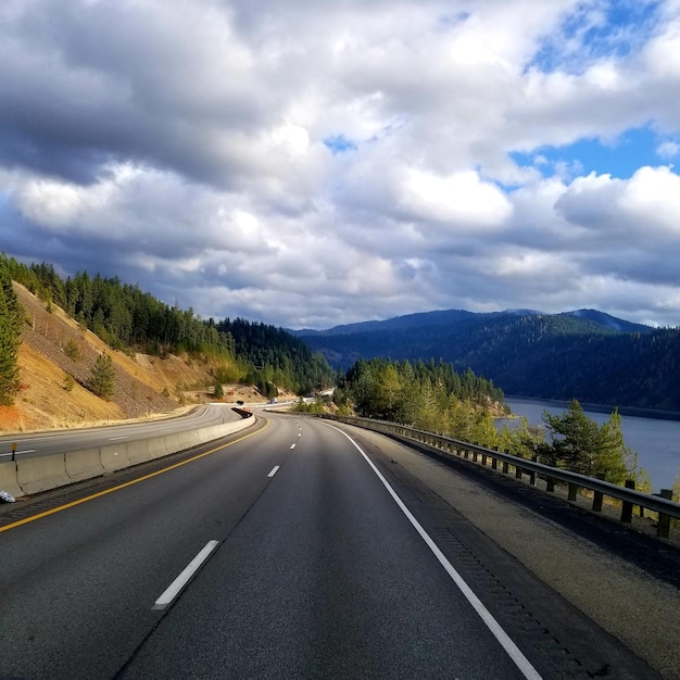 Foto camino que conduce hacia las montañas contra el cielo