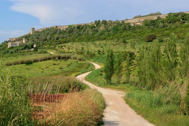 Camino sinuoso en el campo que conduce a la fortaleza El antiguo castillo y muralla de Obidos Portugal Castelo de Obidos Uno de los destinos turísticos más populares