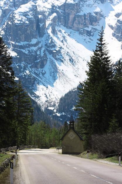 Foto camino sinuoso vacío a las altas montañas nevadas.