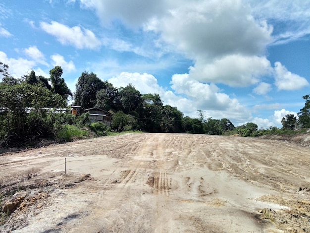 Foto camino de tierra en medio de árboles en el campo contra el cielo