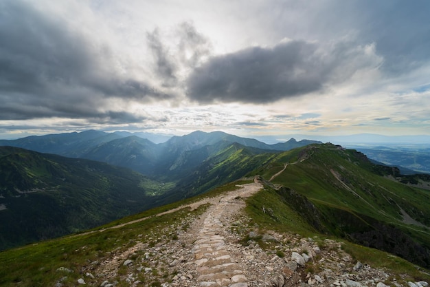 El camino a través de las montañas Tatra en verano el cielo está cubierto de nubes los rayos del sol