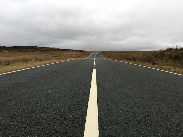 Camino vacío contra el cielo nublado