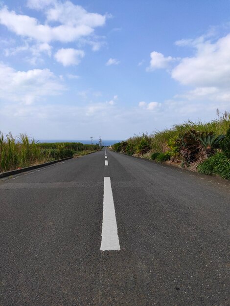 Foto camino vacío contra el cielo