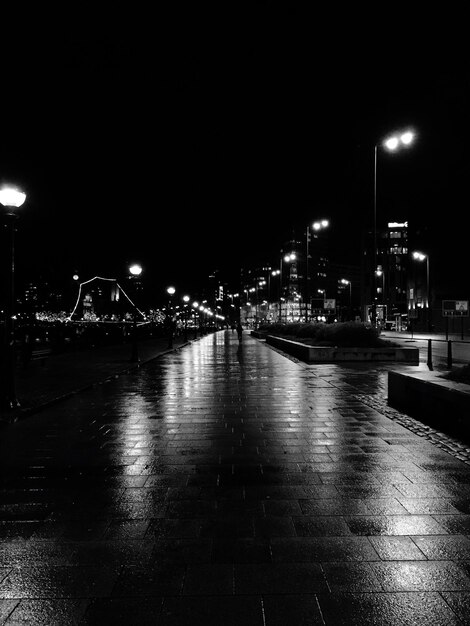 Camino vacío a lo largo de las luces de la calle por la noche