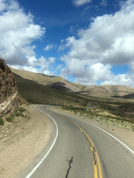 Foto camino vacío a lo largo del paisaje contra el cielo