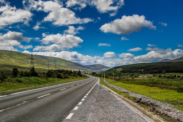 Camino vacío a lo largo del paisaje y las montañas contra el cielo