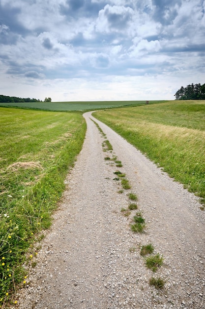 Foto camino vacío en medio del campo contra el cielo