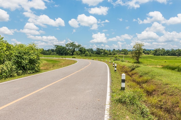 Camino vacío en medio de un campo de hierba contra el cielo