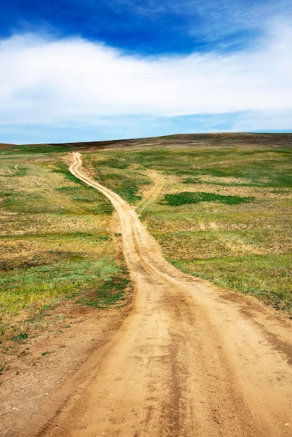 Foto camino vacío que pasa por el campo