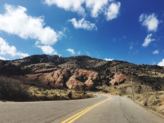 Foto un camino vacío que pasa por las montañas.