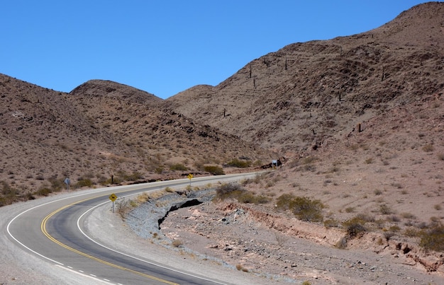 Camino vacío en el viaje por carretera de la zona montañosa seca del paisaje del desierto