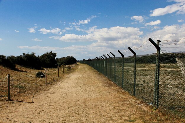 Foto camino por la valla en el campo contra el cielo