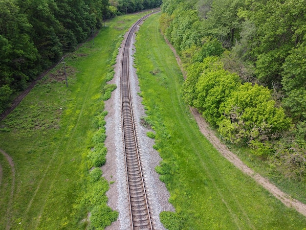 Camino para las vías del tren fuera de la ciudad donde la hermosa naturaleza y el aire fresco