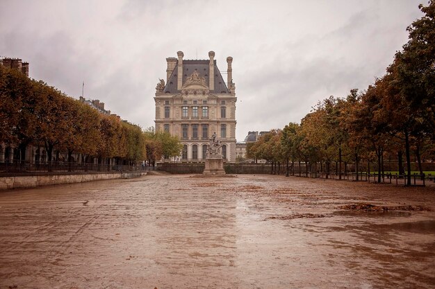 Foto los caminos húmedos de las tuileries conducen al famoso museo de parís la belleza brilla en la lluvia de otoño concepto de viaje