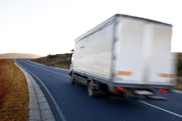 Camión blanco se mueve rápido en una carretera asfaltada.