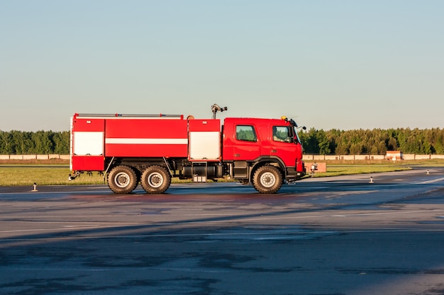 Camión de bomberos del aeródromo rojo en la plataforma del aeropuerto