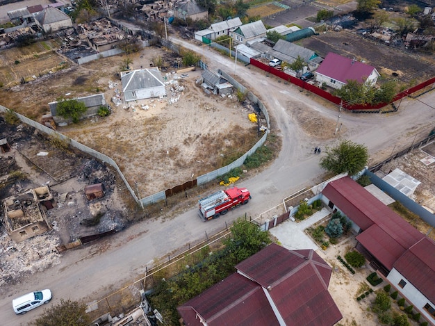 El camión de bomberos está en el pueblo destruido después del incendio Foto aérea