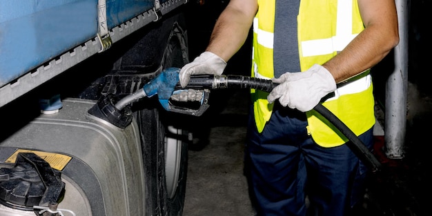 Camión de combustible técnico de cultivo en la gasolinera