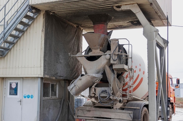 Camión hormigonera carga hormigón en la fábrica Transporte de hormigón al sitio de construcción Equipo de construcción para la entrega de hormigón