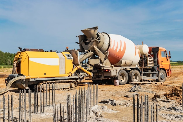 Camión hormigonera entrega hormigón a la bomba para verter pilas Bomba de hormigón en el sitio de construcción Primer plano de la entrega de hormigón