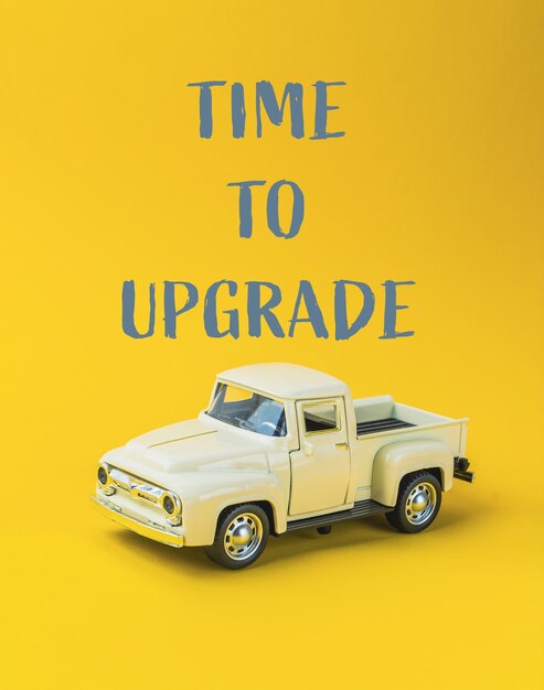 Un camión de juguete está sentado en un fondo amarillo con las palabras Hora de actualizar