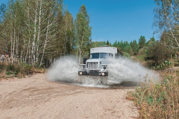 Camion pasa por un charco.