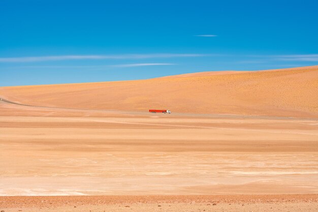 Camión pasando por el desierto contra el cielo