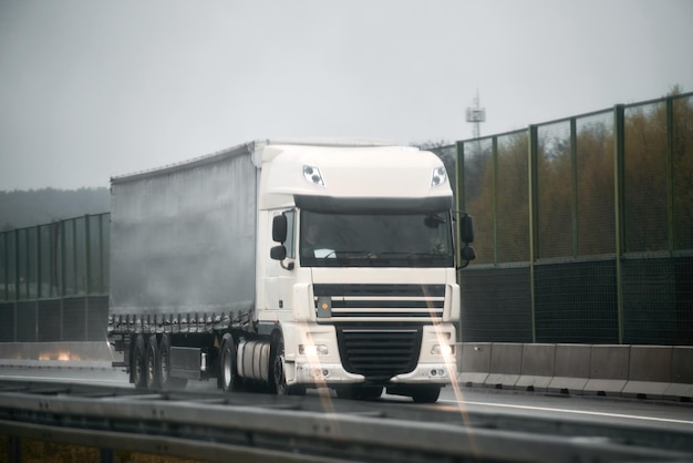 Camión de reparto en la autopista de Europa Semirremolque con remolque de carga conduciendo en el túnel Camión de movimiento rápido Camionero monta su camión moderno