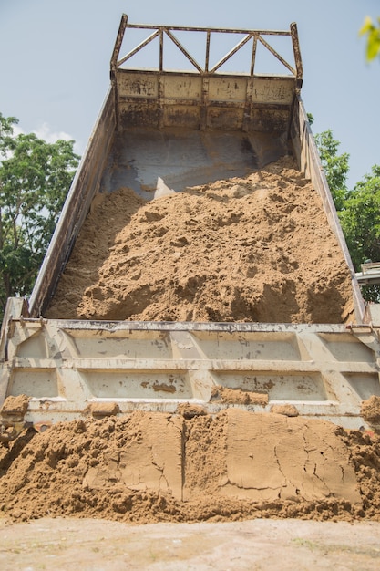 Camión volquete descargando arena en el sitio de construcción