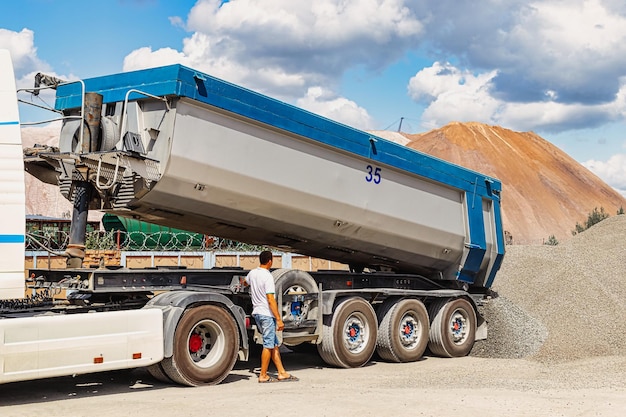 Foto un camión volquete grande descarga escombros o grava en un sitio de construcción tonar de automóvil para el transporte de carga pesada a granel proporcionar materiales al sitio de construcción