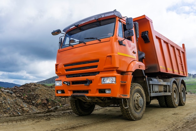 Camión volquete paseos en la carretera de montaña en construcción