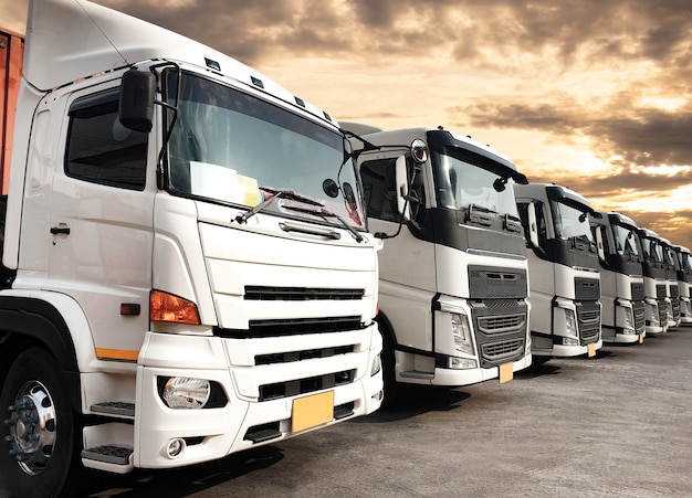 Camiones estacionados alineados en el cielo del atardecer, logística y transporte de la industria de transporte por carretera