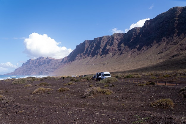 Una camioneta blanca está estacionada en la tierra.