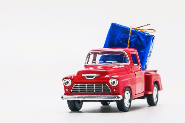 Camioneta retro roja con una caja de regalo azul aislada